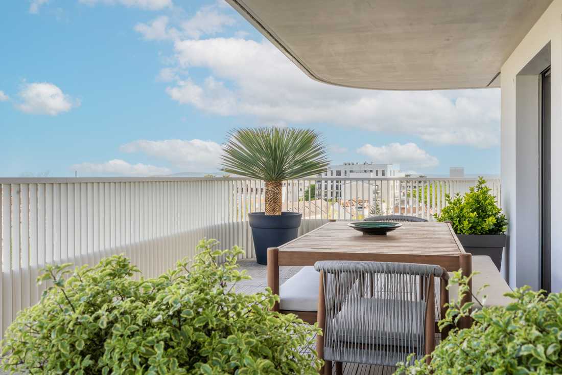 Table à manger en bois sur la terrasse végétalisée, avec vue dégagée