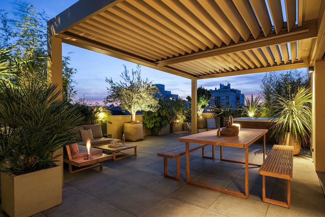 Terrasse bioclimatique avec pergola - espace repas avec table - vue nocturne
