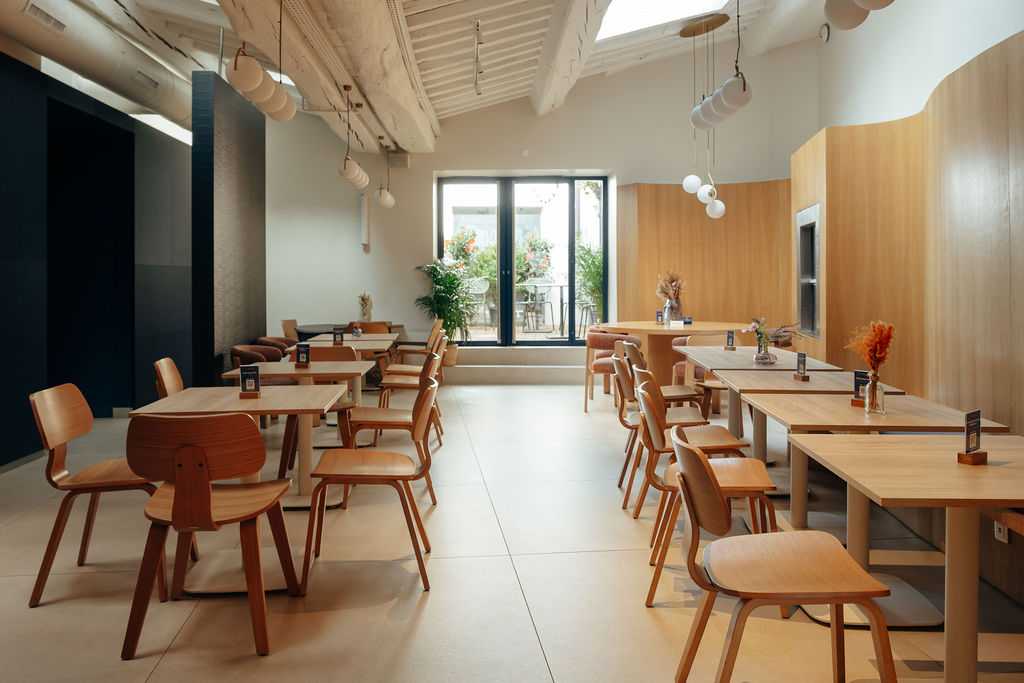 Salle de restaurant rénovée avec charpente en bois et poutres centenaires, Paris 18e