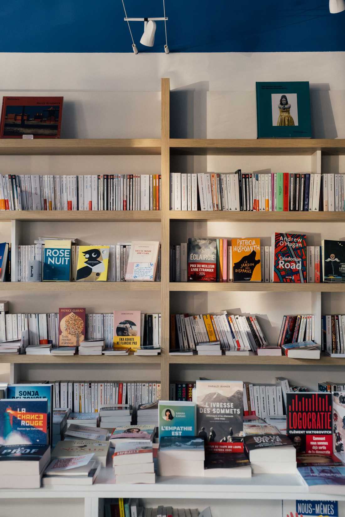 Aménagement d'une librairie à Paris 15 - Étagères bois et blanc, table des nouveautés