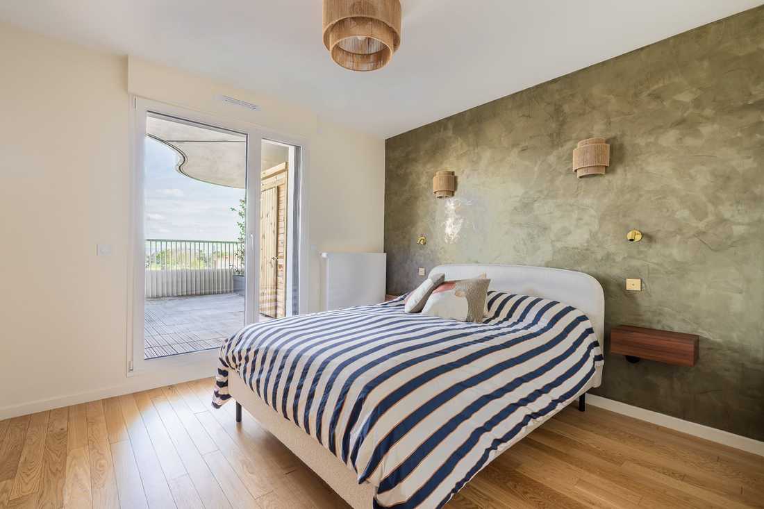 Suite parentale avec mur en enduit vert et accès à la terrasse
