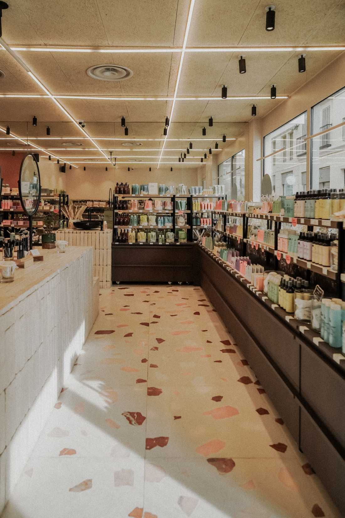 Retail design de la boutique de cosmétiques avec étagères de produits et comptoir en bois clair
