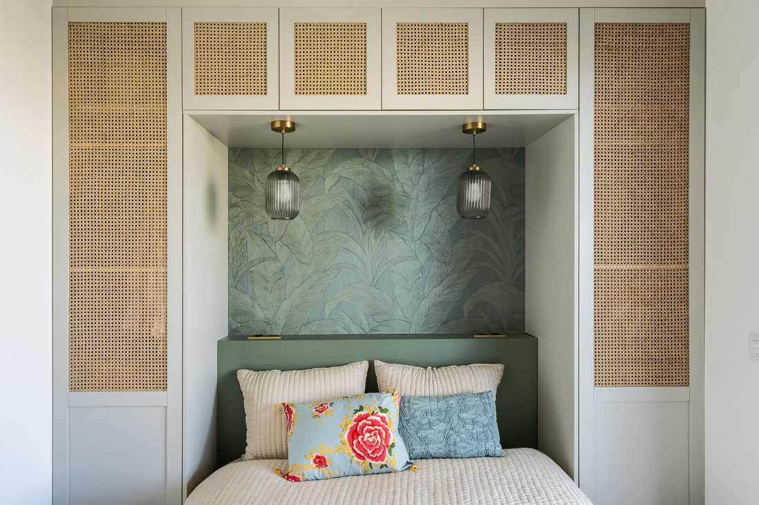 Chambre avec lit encastré dans un rangement sur mesure aux portes en cannage