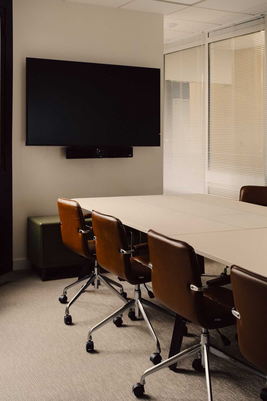 Aménagement du siège social d'une startup - Salle de réunion avec écran et fauteuils en cuir