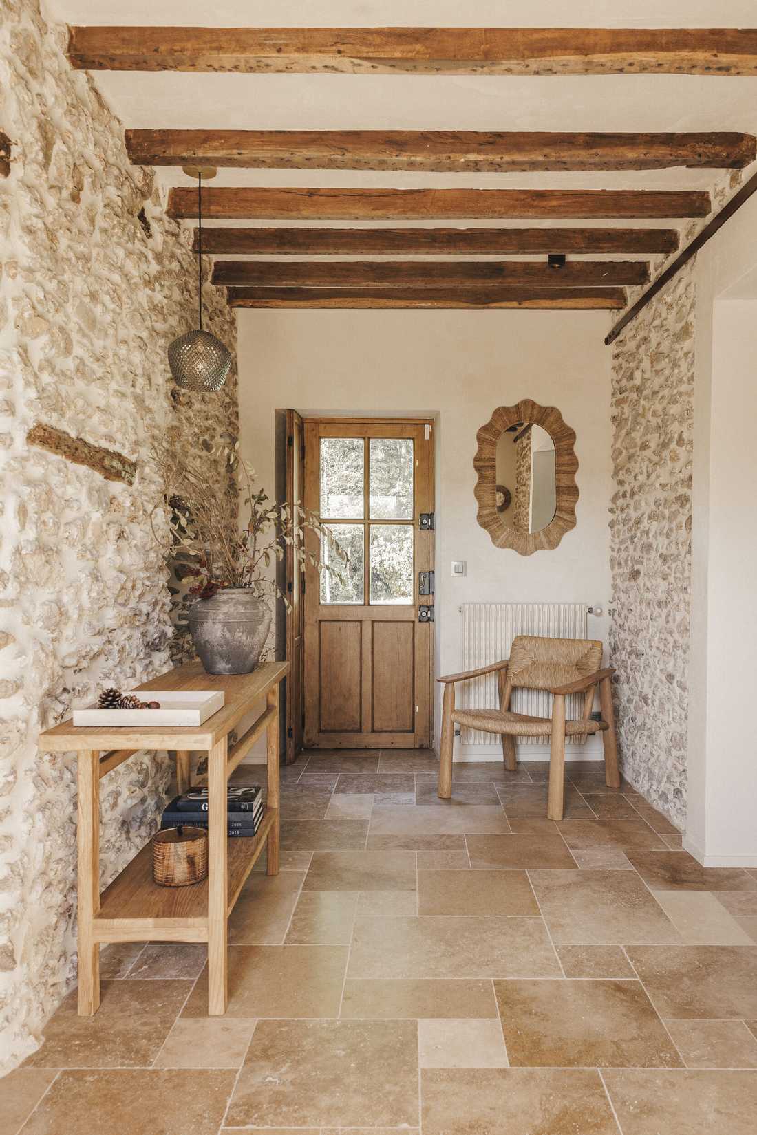 Rénovation complète d’une longère au cœur de la forêt - l'entrée avec console en bois et sol en travertin