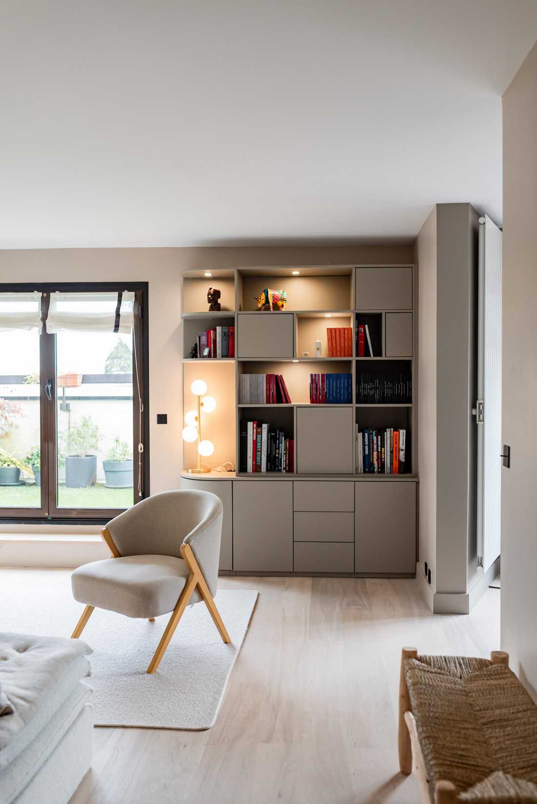 Décoration de la pièce de vie d’un appartement - la bibliothèque sur mesure dessinée par un architecte d'intérieur à Suresnes
