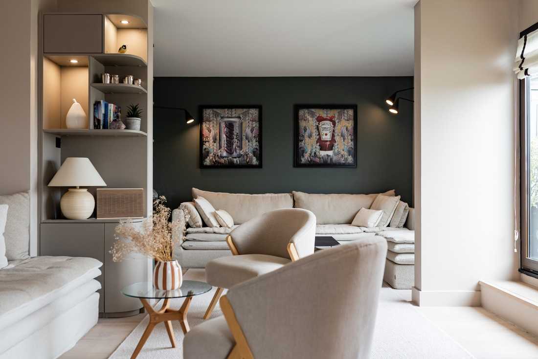 Décoration de la pièce de vie d’un appartement - le salon avec bibliothèque taupe et fauteuils beiges