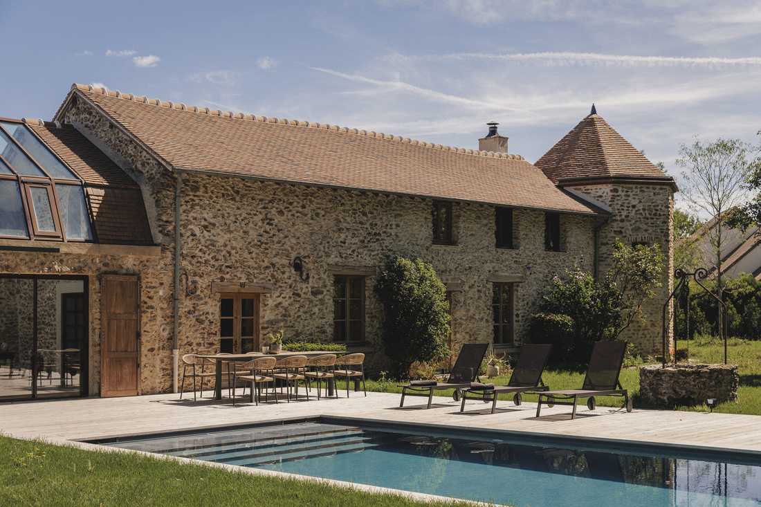 Création d’une piscine dans le jardin d’une longère - la façade en pierre et la piscine