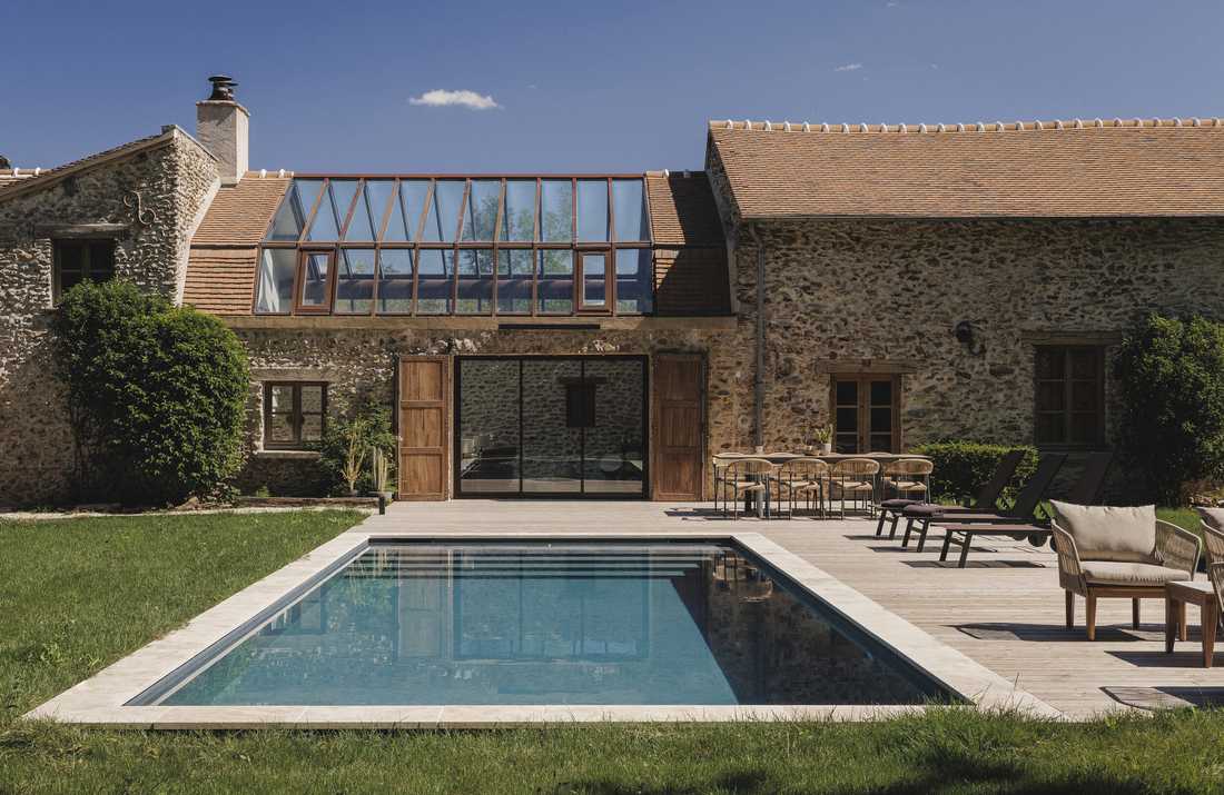 Rénovation complète d’une longère au cœur de la forêt - la façade en pierre et la piscine