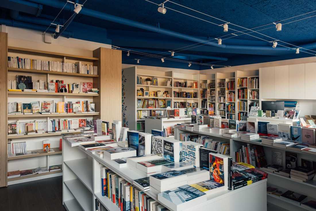Aménagement d'une librairie à Paris 15 - Vue d'ensemble des linéaires bois et blancs