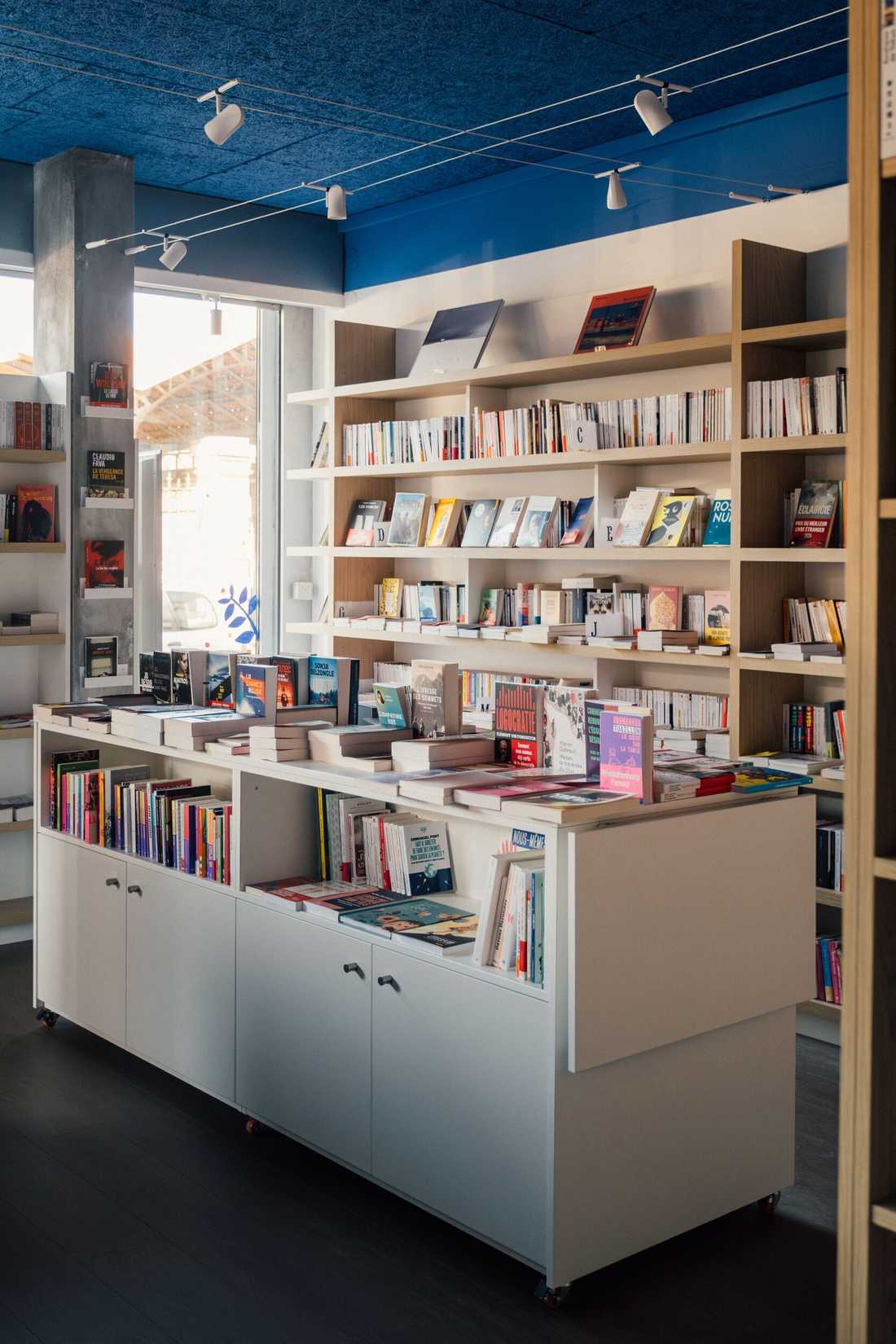 Aménagement d'une librairie à Paris 15 - Îlot central avec rangements près de la baie vitrée