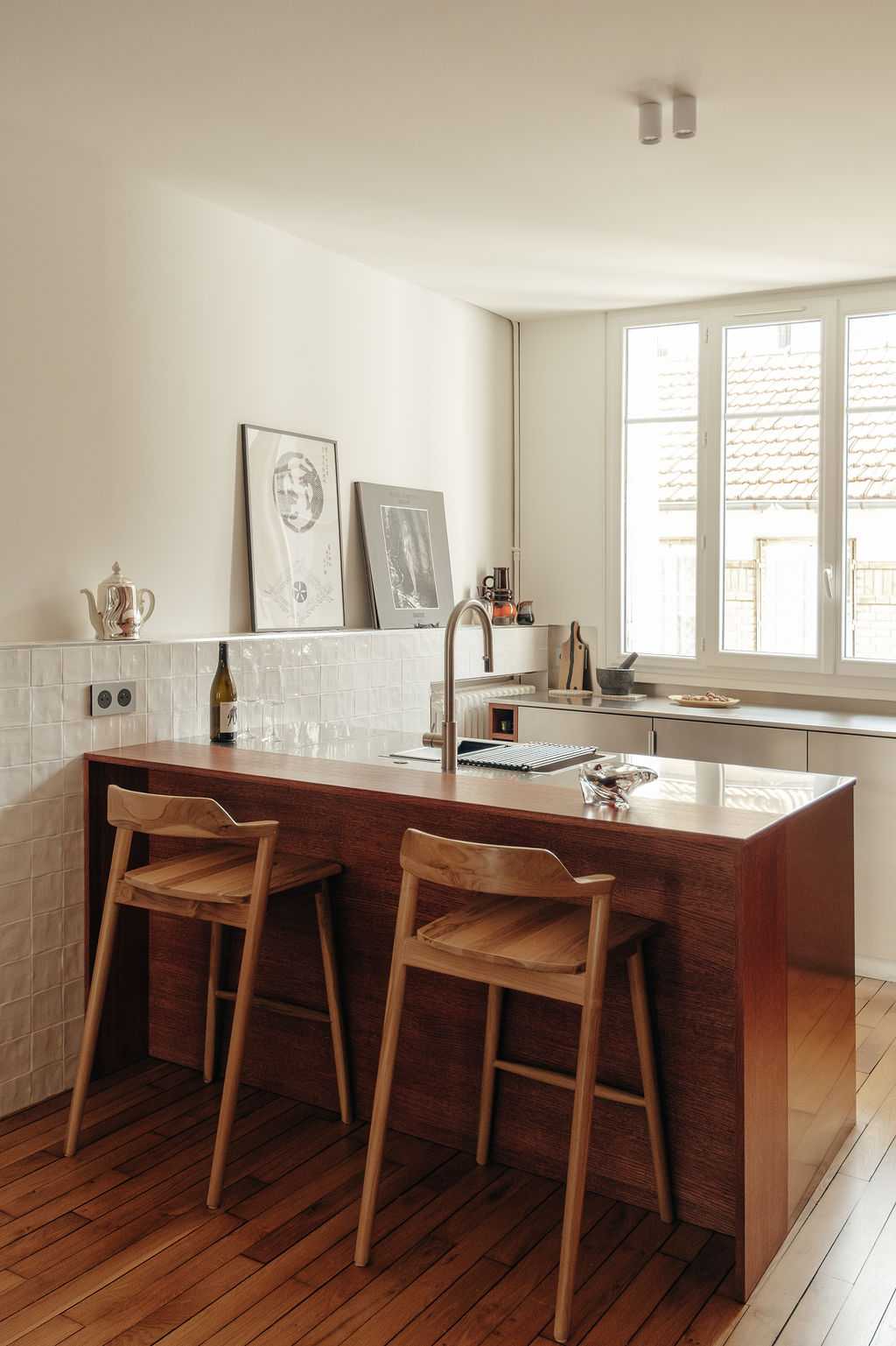 Restructuration d'un appartement à Paris 17 - la cuisine avec comptoir et tabourets