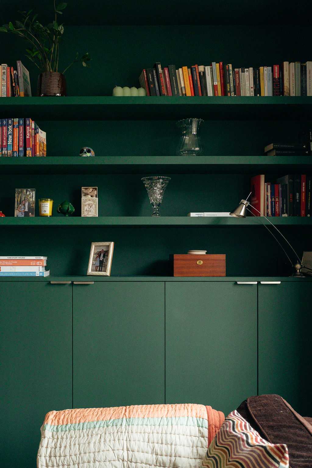 Restructuration d'un appartement à Paris 17 - la bibliothèque sur mesure vert foncé du salon