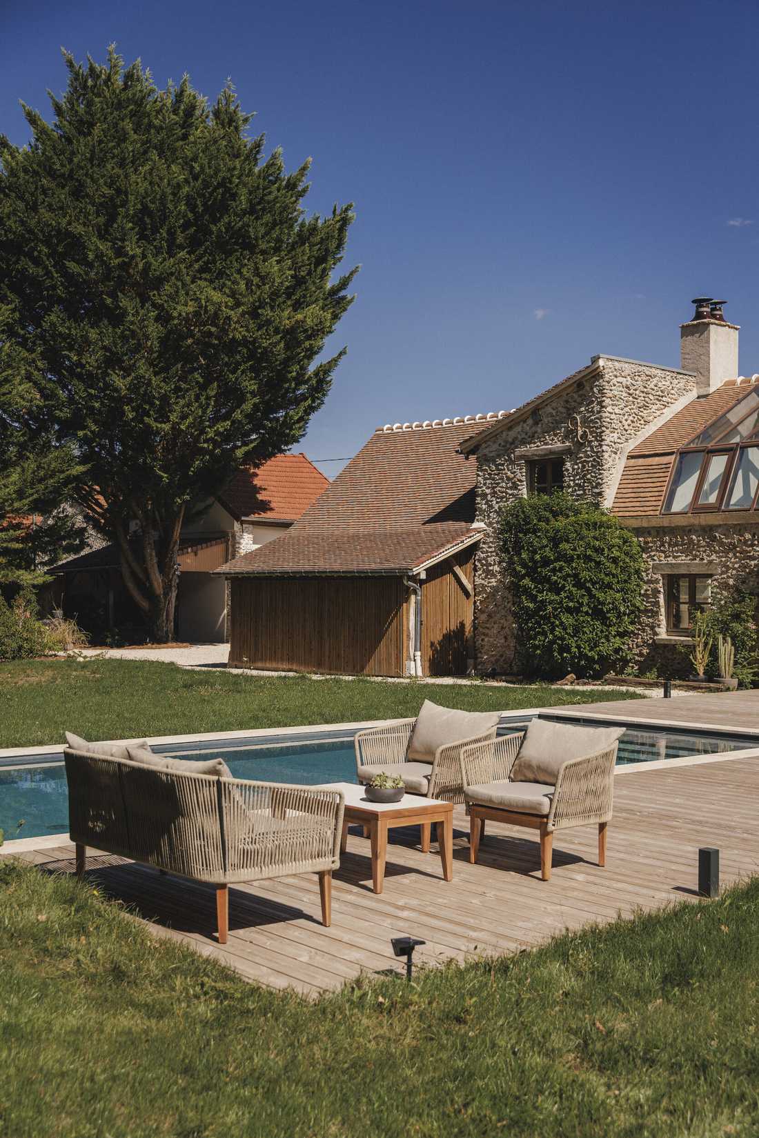 Création d’une piscine dans le jardin d’une longère - le salon extérieur sur la terrasse en bois