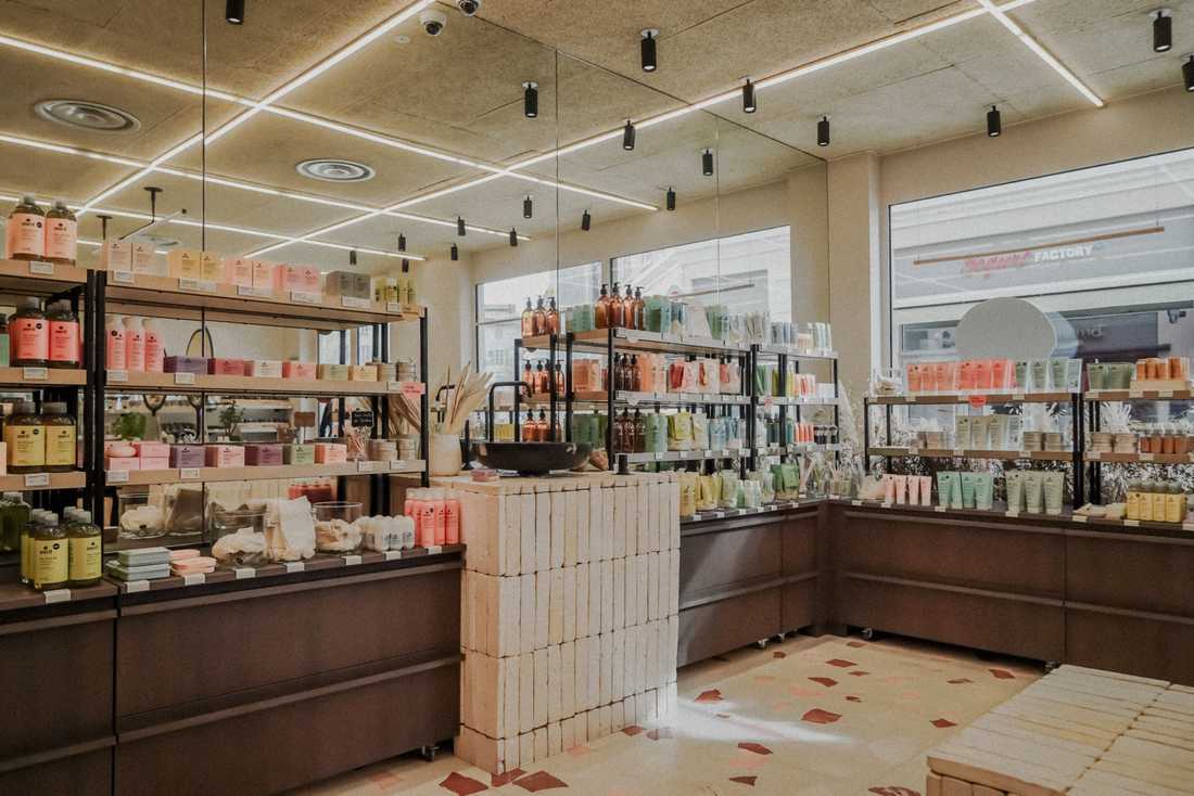 Rénovation intérieure de la boutique de cosmétiques avec îlot en briques de terre cuite et étagères de produits