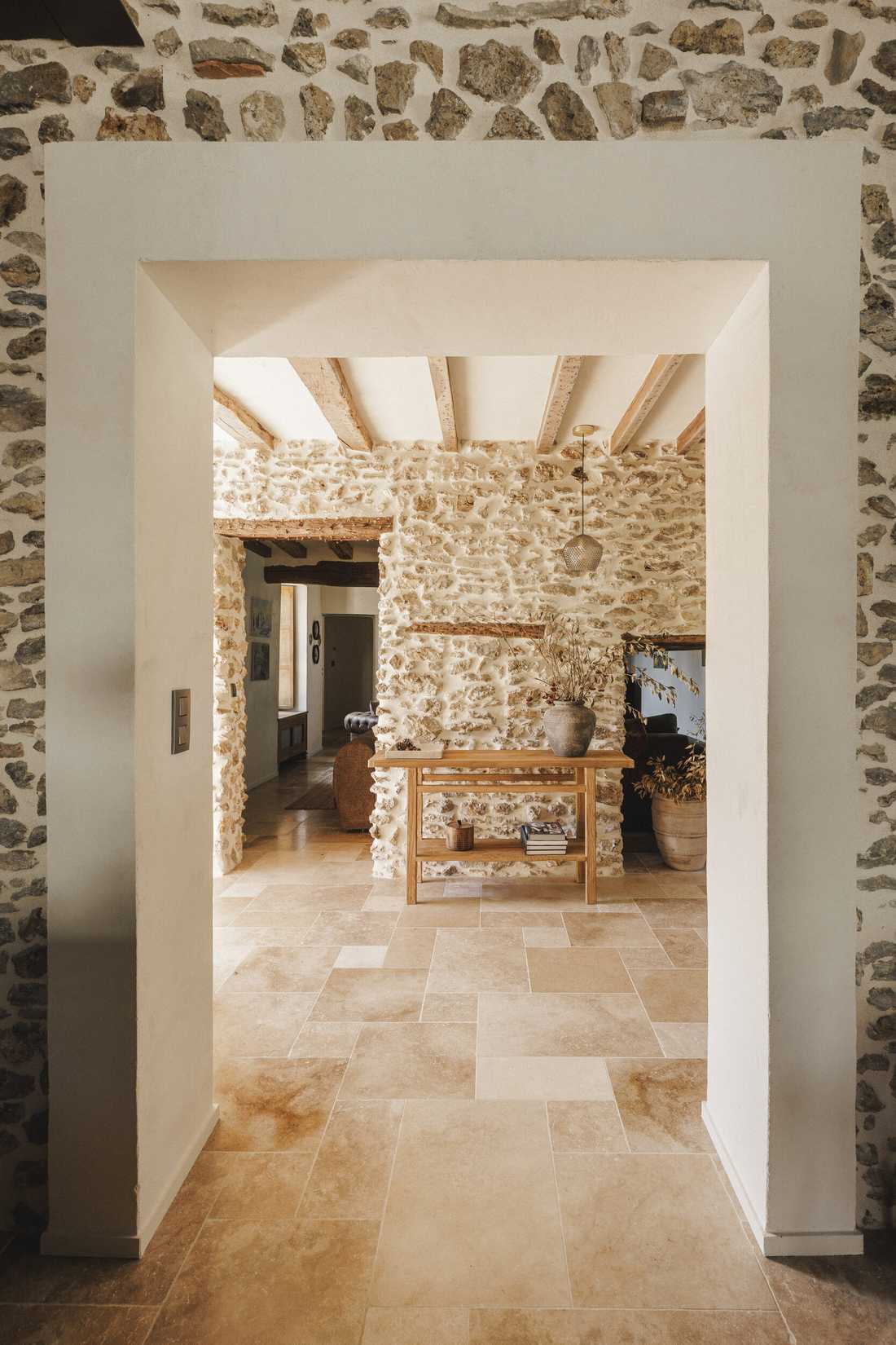 Rénovation complète d’une longère au cœur de la forêt - enfilade depuis l'entrée à travers un encadrement dans le mur en pierre