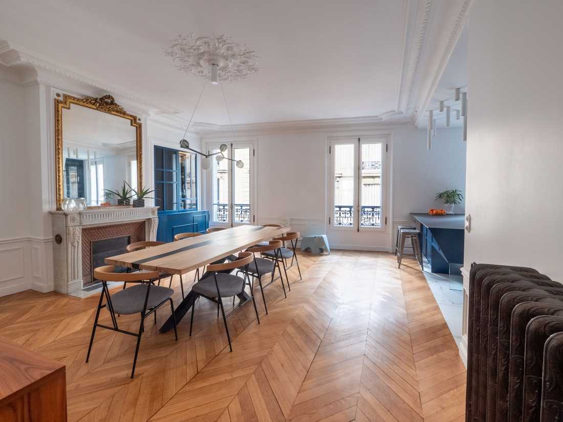 Salle à manger ouverte sur la cuisine dans un appartement haussmannien