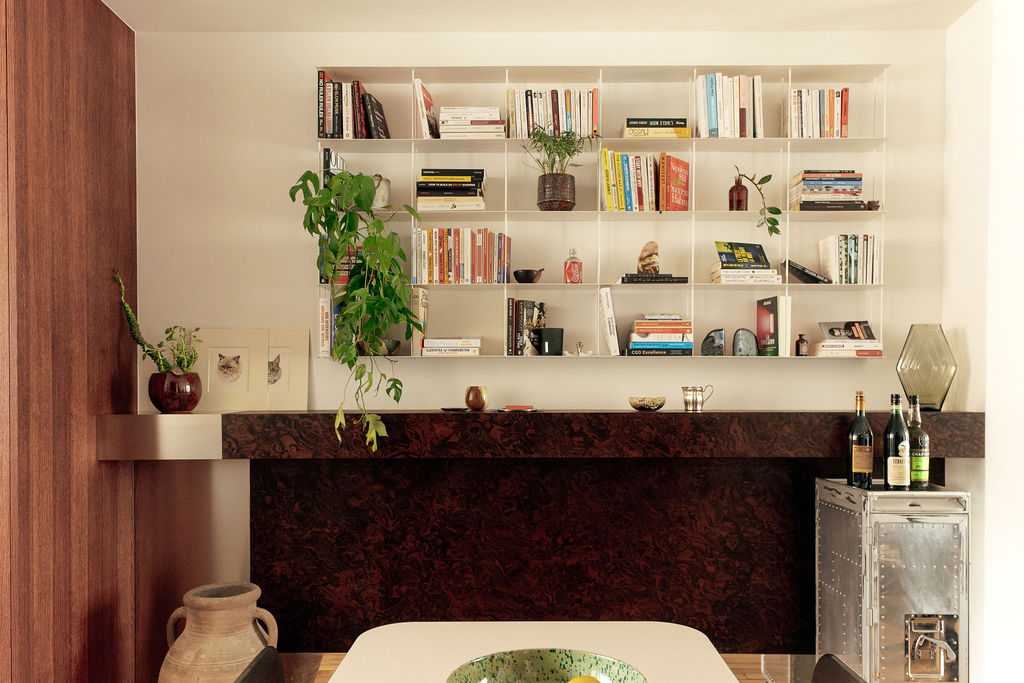 Restructuration d'un appartement à Paris 17 - l'agencement en bois de loupe et la bibliothèque du séjour