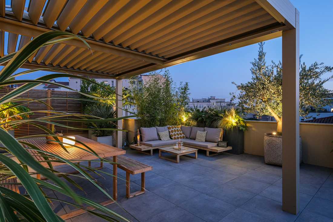 Terrasse bioclimatique avec pergola - espace détente avec canapé d'angle - vue nocturne