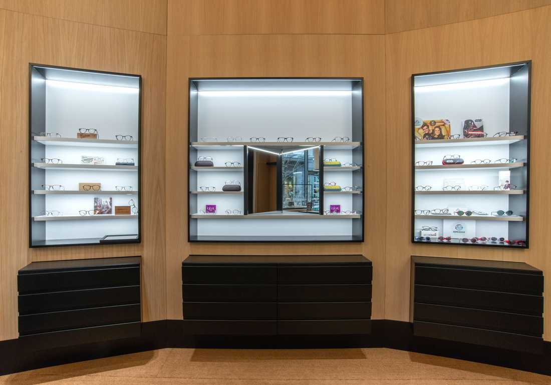 Grands éléments muraux en chêne clair dans une boutique d'opticien