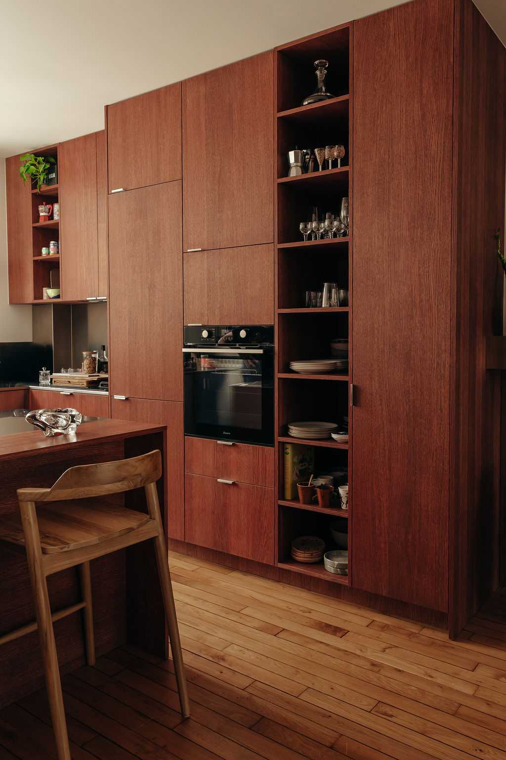 Restructuration d'un appartement à Paris 17 - les colonnes de cuisine en bois teinte merisier