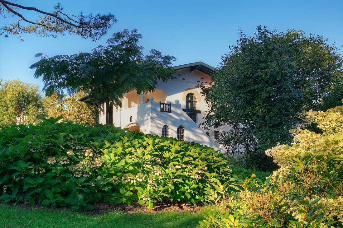 Aménagement paysager autour d'une maison basque - vue sur la façade entre la végétation