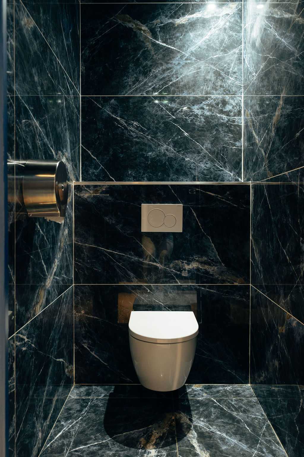 Passage vers les toilettes du restaurant avec un grand miroir brise-vue