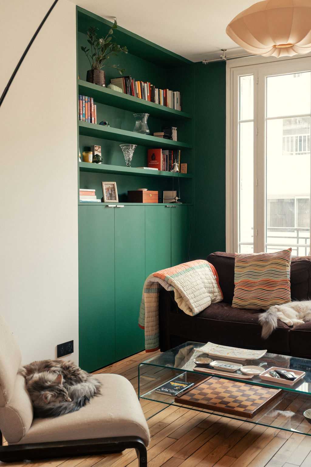 Restructuration d'un appartement à Paris 17 - bibliothèque sur mesure verte dans le salon