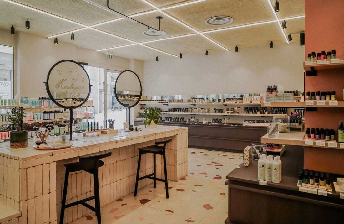 Aménagement intérieur de la boutique de cosmétiques bio Avril à Antibes, avec comptoir en brique de terre cuite et sol en terrazzo