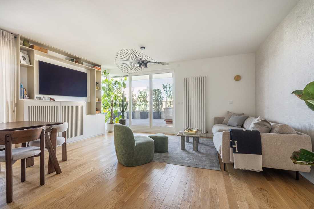 Séjour avec meuble TV sur mesure et baie vitrée donnant sur la terrasse