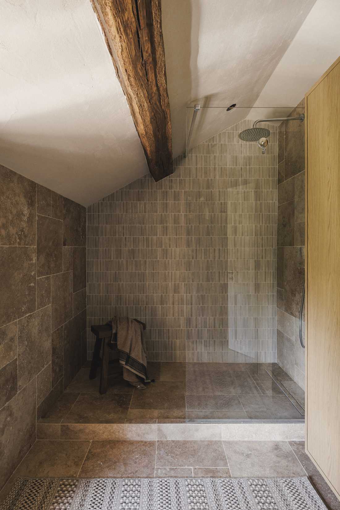Rénovation complète d’une longère au cœur de la forêt - la douche à l'italienne en pierre naturelle sous la pente du toit