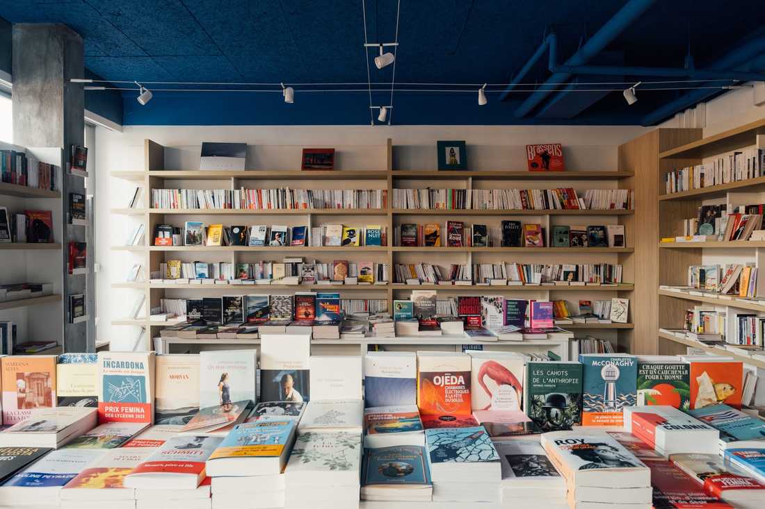 Aménagement d'une librairie à Paris 15 - Étagères murales en bois et table de livres