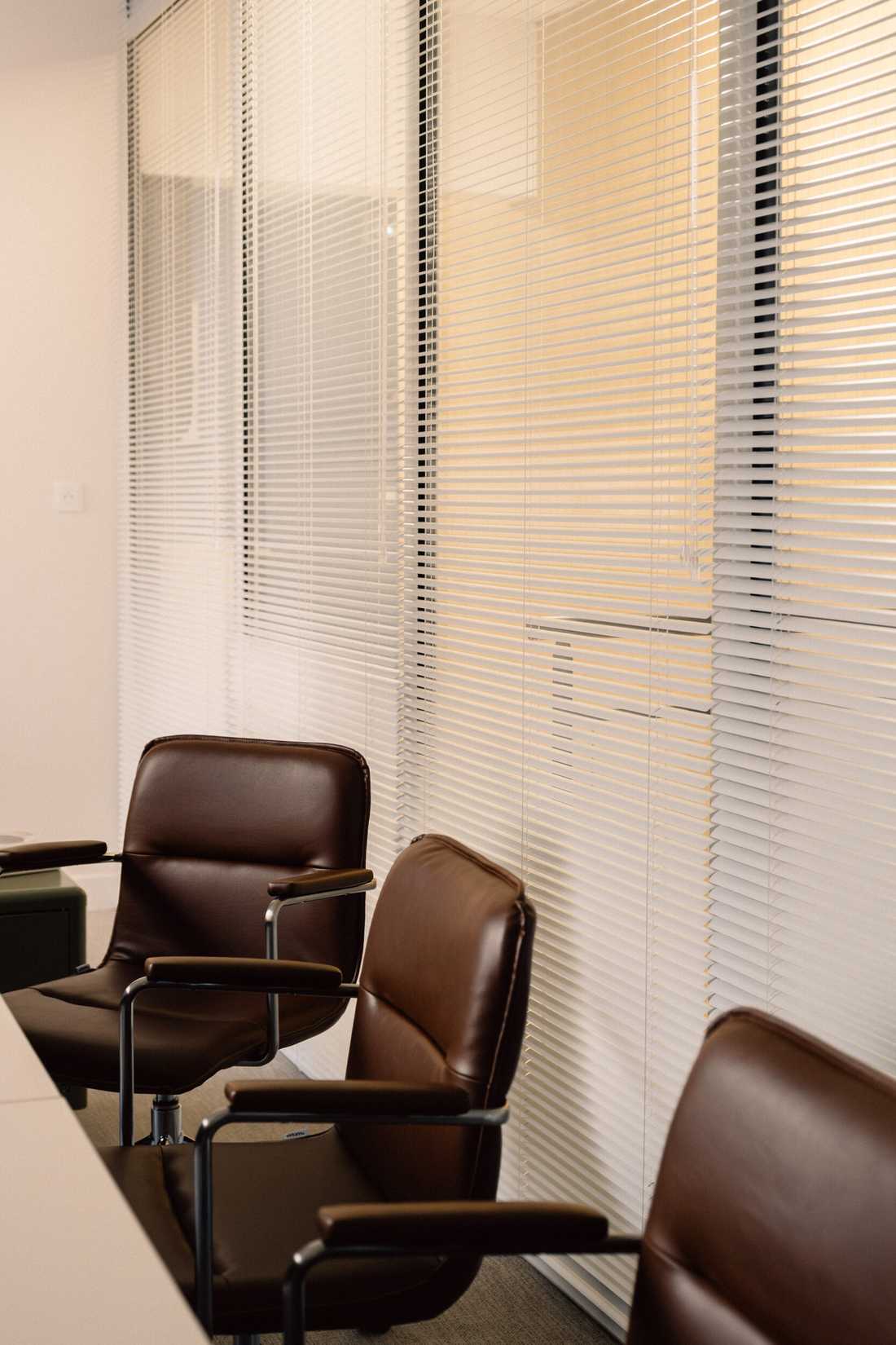 Aménagement du siège social d'une startup - Fauteuils en cuir et stores de la salle de réunion