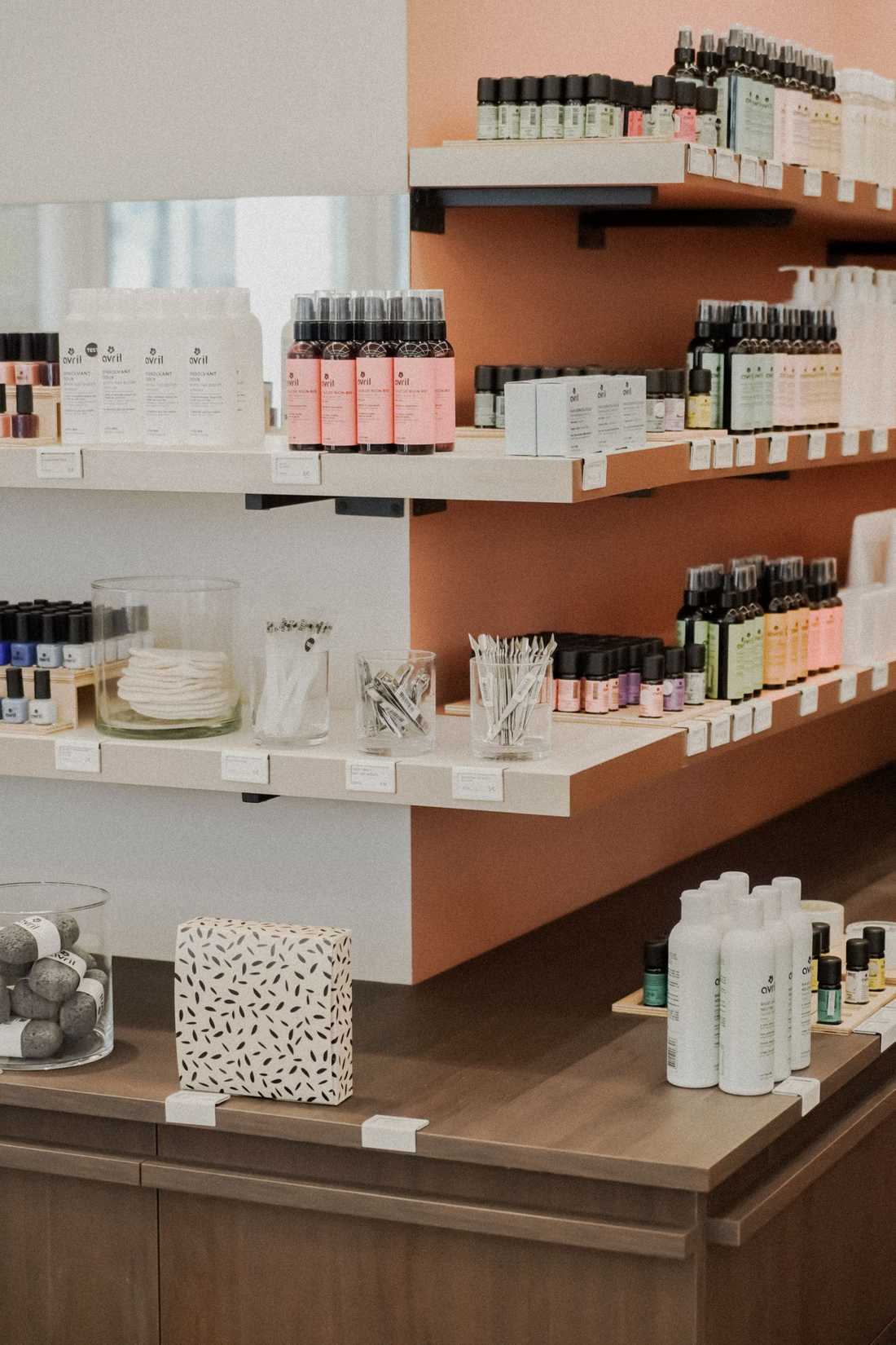 Présentoirs muraux en bois présentant les produits de cosmétique bio Avril, vernis à ongles et huiles