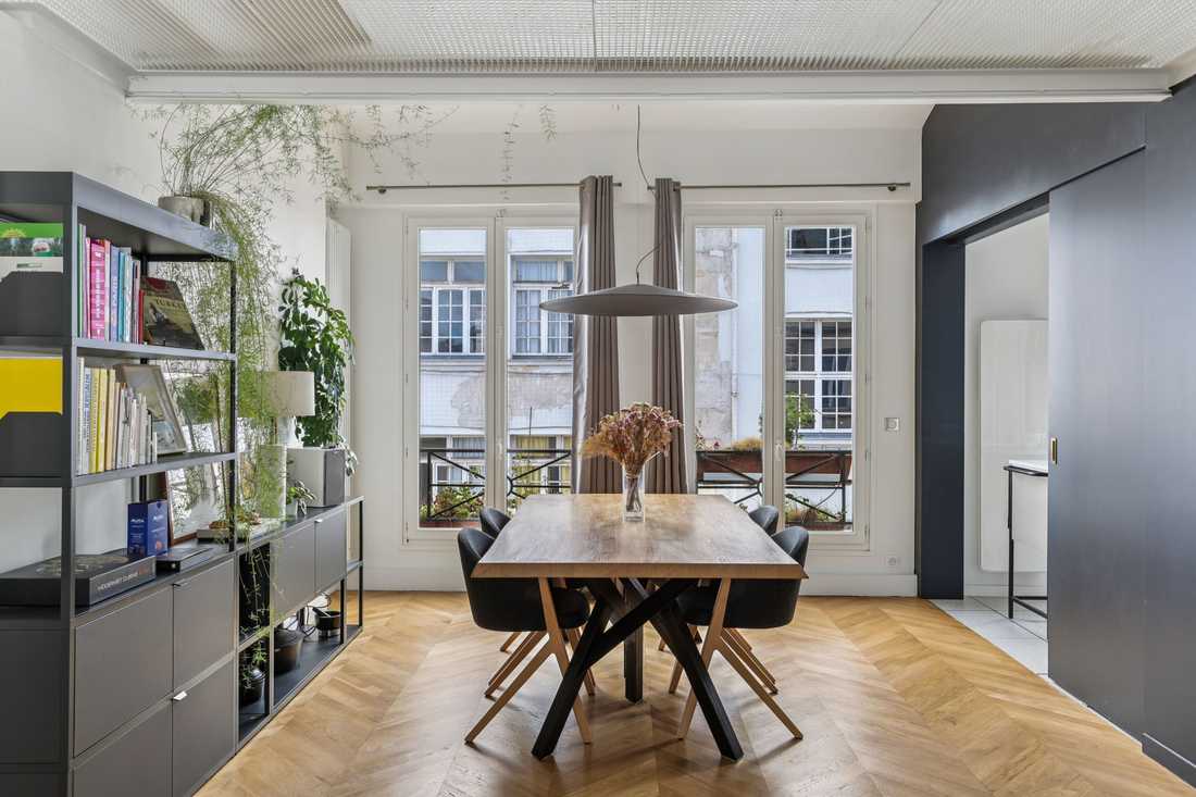 Salle à manger avec table en bois massif et parquet point de Hongrie