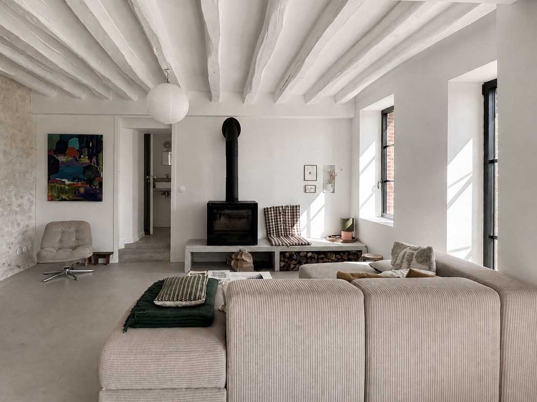 Rénovation d’une maison ancienne dans le Perche - salon avec poutres anciennes peintes en blanc